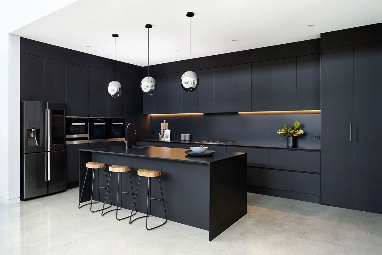 Black kitchen with countertops and chairs