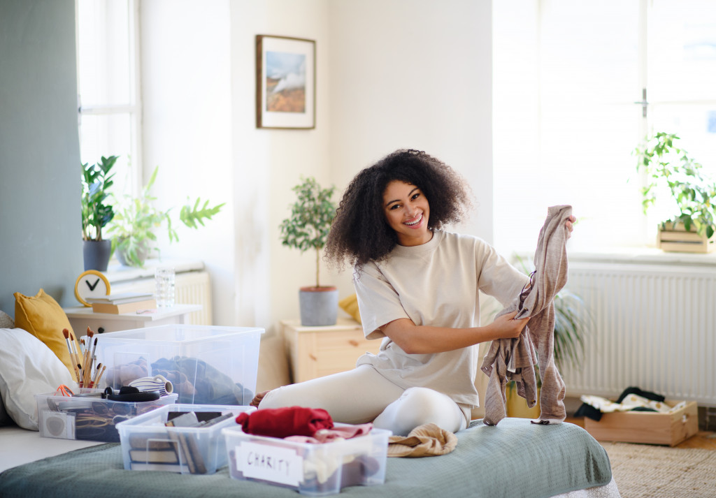 Young woman organizing her belongings in a bedroom.