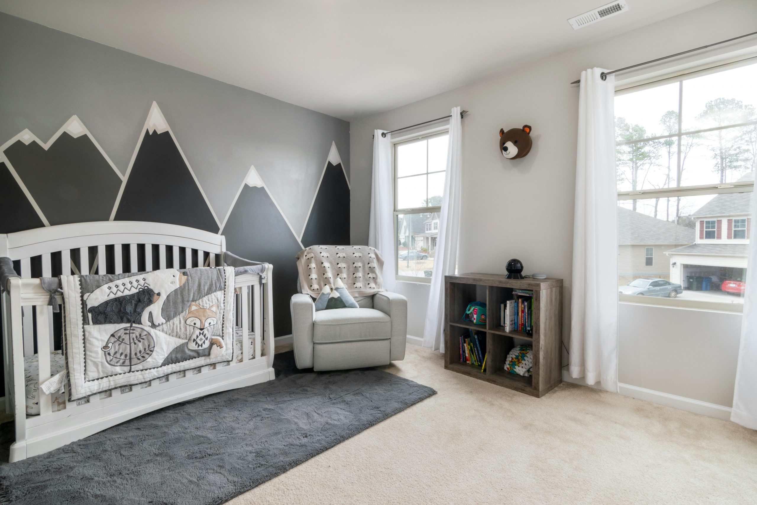 nursery featuring mountain range wall art on one wall